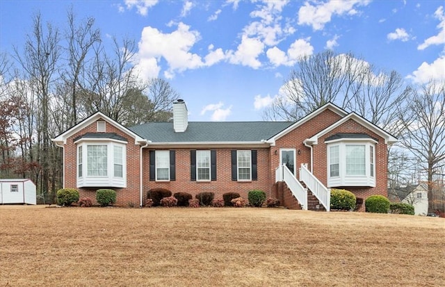 view of front of property featuring a front lawn and a storage unit