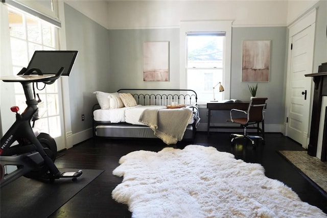 bedroom with dark wood-type flooring, baseboards, and multiple windows