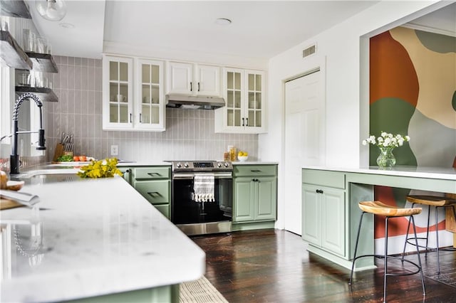 kitchen featuring visible vents, dark wood finished floors, under cabinet range hood, stainless steel electric range, and green cabinets