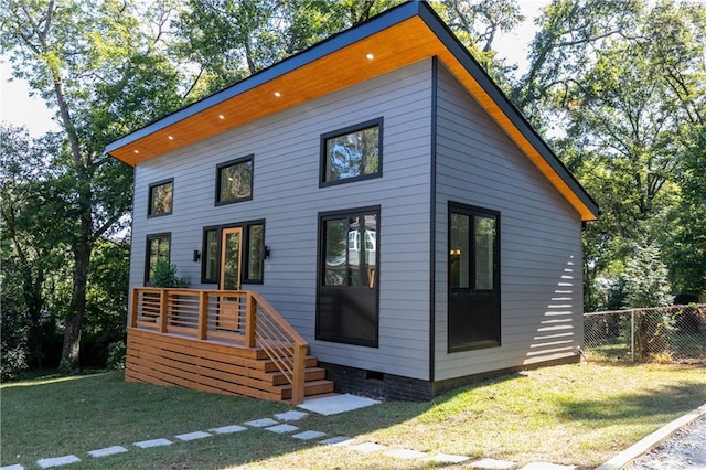 view of front of house featuring a front lawn, fence, and crawl space