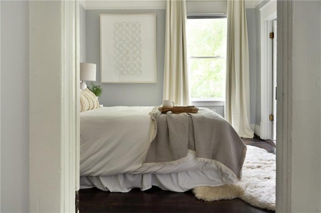 bedroom featuring ornamental molding and wood finished floors