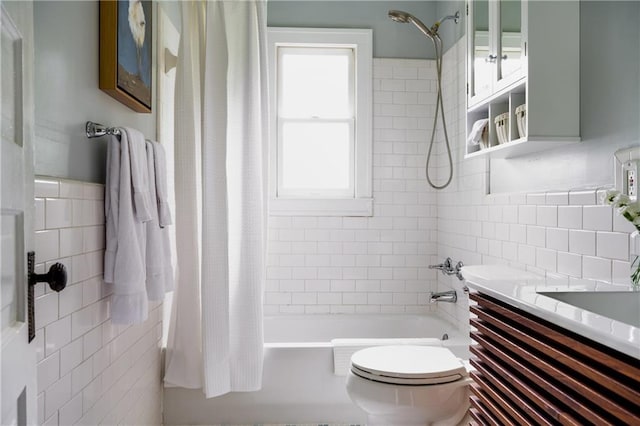 bathroom with toilet, tile walls, shower / tub combo with curtain, and vanity