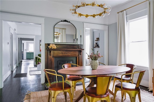 dining area featuring dark wood finished floors, baseboards, a fireplace, and a healthy amount of sunlight