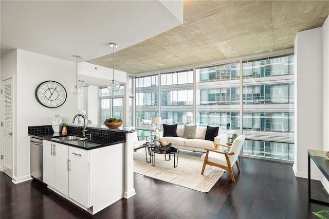 923 Peachtree St NE Unit 1238, Atlanta, GA 30309 - kitchen with dark wood-style floors, stainless steel dishwasher, a peninsula, hanging light fixtures, and a wall of windows