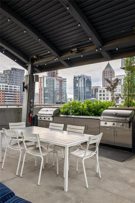 923 Peachtree St NE Unit 1238, Atlanta, GA 30309 - view of patio featuring outdoor dining area, a city view, and an outdoor kitchen