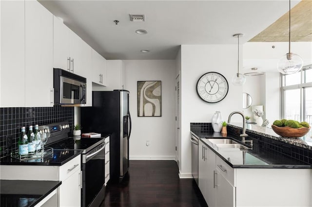 923 Peachtree St NE Unit 1238, Atlanta, GA 30309 - kitchen featuring appliances with stainless steel finishes, dark countertops, dark wood-type flooring, a peninsula, and recessed lighting