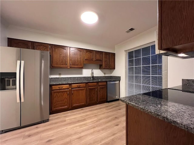 1271 Whitlock Ridge Dr SW, Marietta, GA 30064 - kitchen featuring appliances with stainless steel finishes, light wood-style flooring, crown molding, dark stone countertops, and dark brown cabinetry