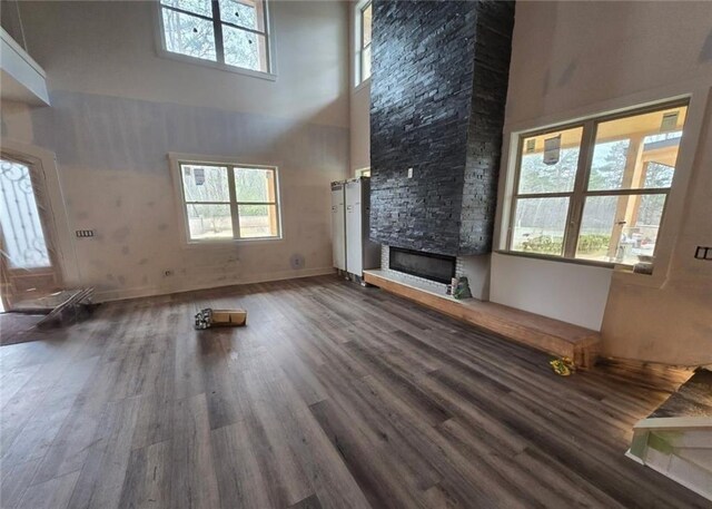 300 Mountain Ridge Dr, Dahlonega, GA 30533 - unfurnished living room with a fireplace, a towering ceiling, plenty of natural light, and wood finished floors
