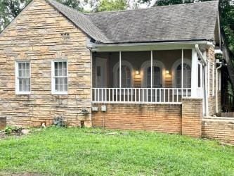 view of property exterior with a lawn and a sunroom