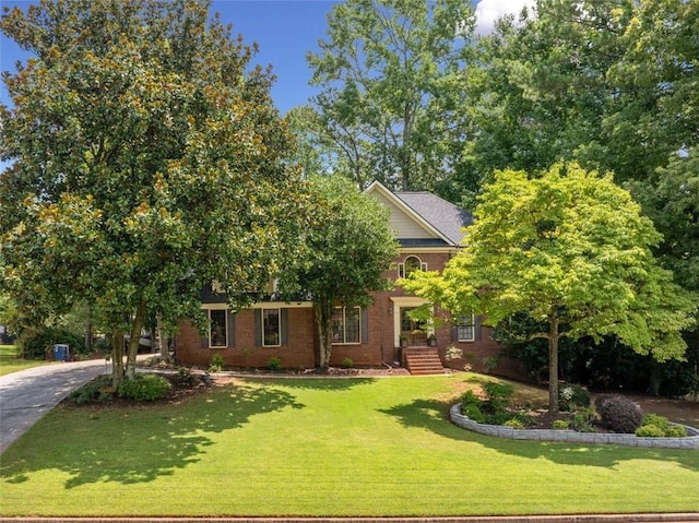 view of property hidden behind natural elements with a front yard