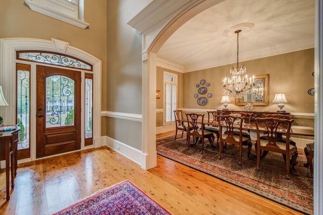 foyer entrance featuring crown molding, a chandelier, and hardwood / wood-style flooring