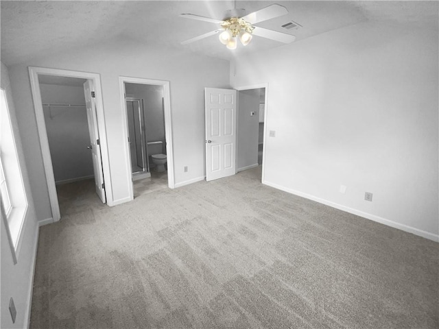 4279 Orchard Grv, Stone Mountain, GA 30083 - unfurnished bedroom with vaulted ceiling, a walk in closet, a closet, baseboards, and carpet