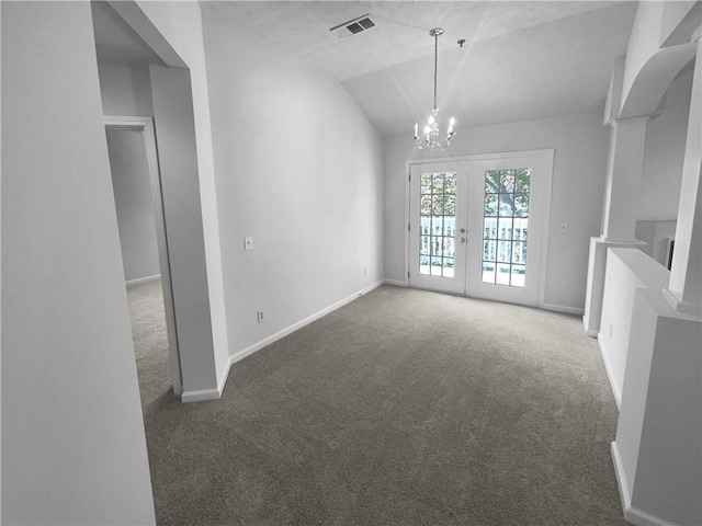 unfurnished living room featuring a chandelier, french doors, dark carpet, and vaulted ceiling