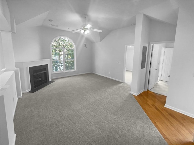 unfurnished living room featuring electric panel, hardwood / wood-style flooring, ceiling fan, and lofted ceiling