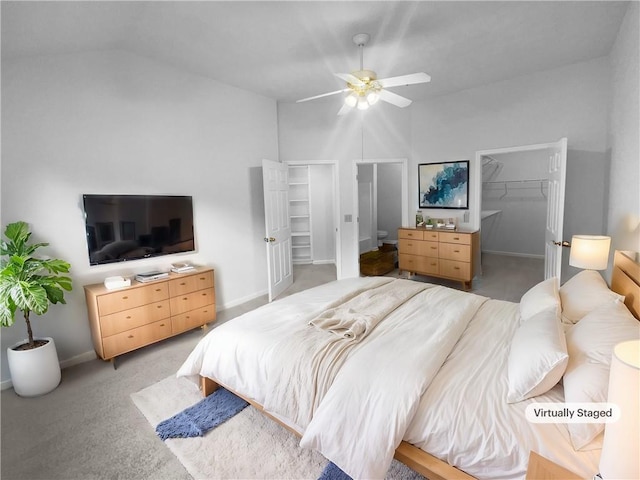 carpeted bedroom with a walk in closet, ceiling fan, a closet, and vaulted ceiling