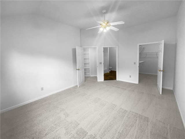 unfurnished bedroom with ceiling fan, a spacious closet, carpet floors, and a closet