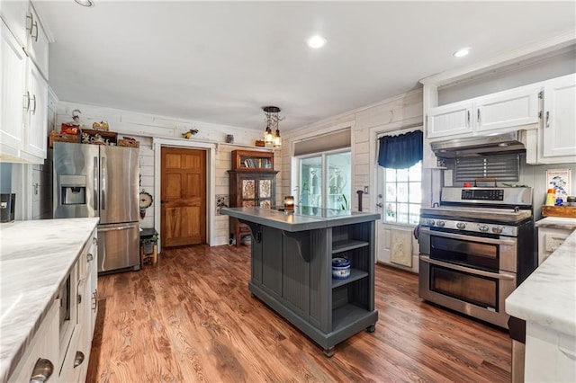 kitchen featuring stainless steel appliances, light stone counters, dark hardwood / wood-style flooring, white cabinets, and ornamental molding