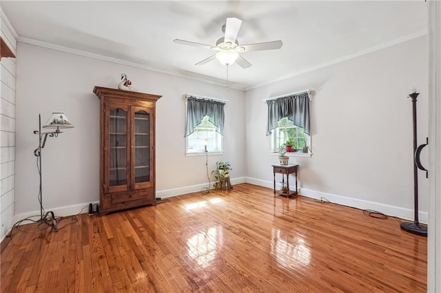 empty room with ceiling fan, crown molding, and wood-type flooring