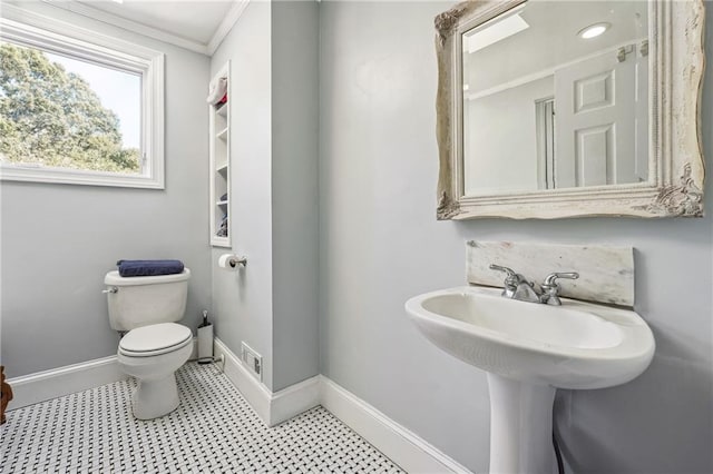 bathroom with toilet, ornamental molding, and sink