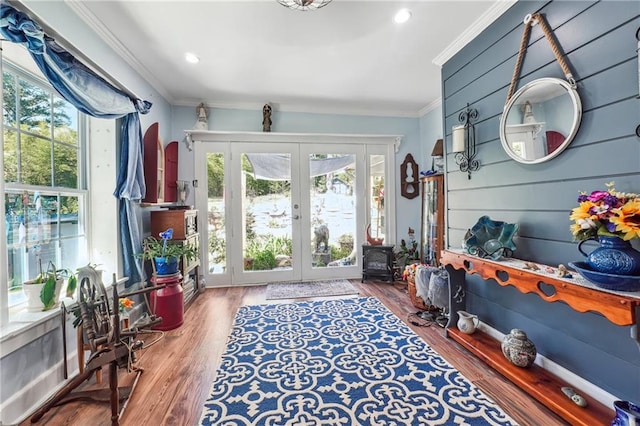 doorway with wood-type flooring, crown molding, and french doors