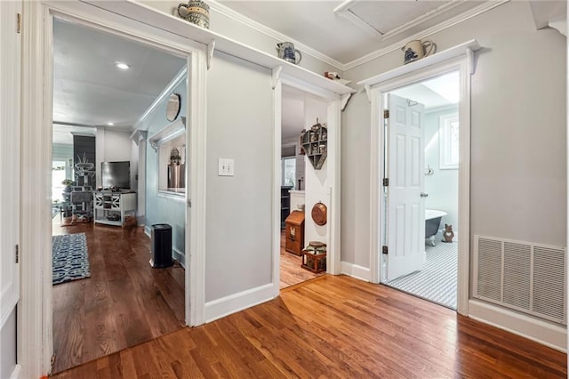 corridor with wood-type flooring and ornamental molding