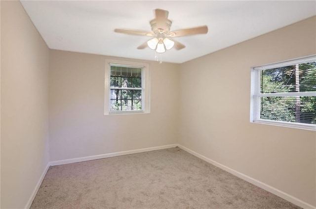 unfurnished room featuring light colored carpet and ceiling fan