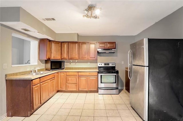 kitchen featuring sink, appliances with stainless steel finishes, and light tile patterned flooring