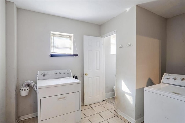 laundry area with separate washer and dryer and light tile patterned floors