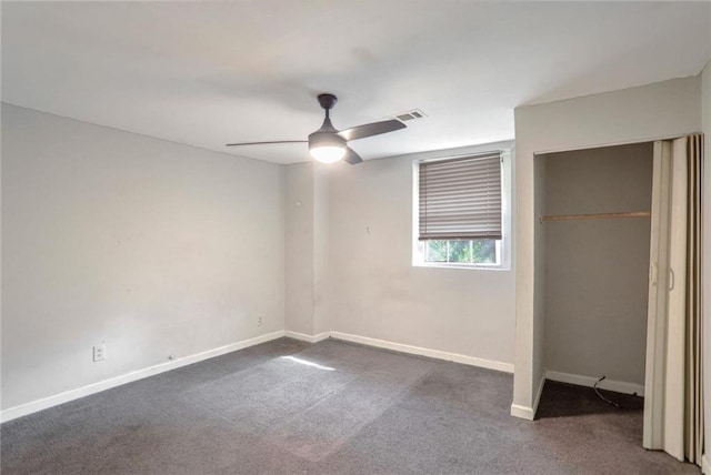 unfurnished bedroom with dark carpet, a closet, and ceiling fan