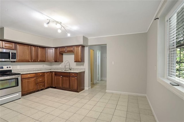 kitchen featuring ornamental molding, sink, appliances with stainless steel finishes, and light tile patterned floors