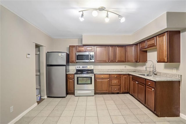 kitchen with light stone counters, appliances with stainless steel finishes, ornamental molding, light tile patterned flooring, and sink