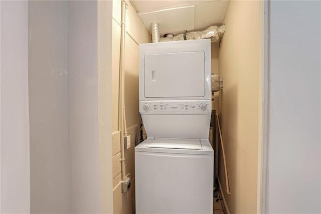 clothes washing area featuring stacked washer / dryer