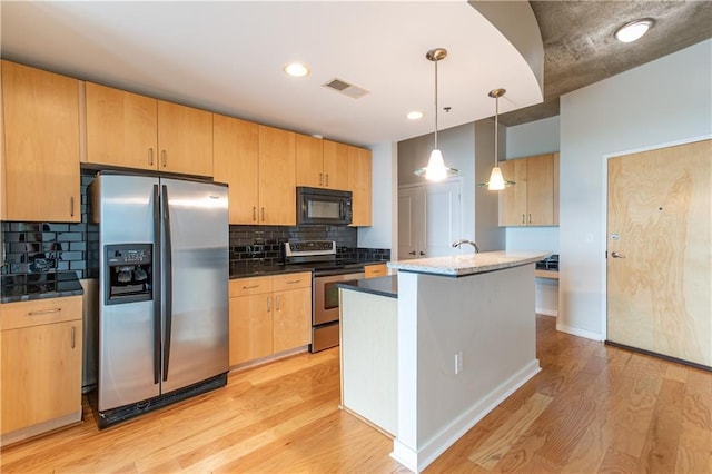 kitchen with visible vents, light wood finished floors, decorative backsplash, appliances with stainless steel finishes, and pendant lighting