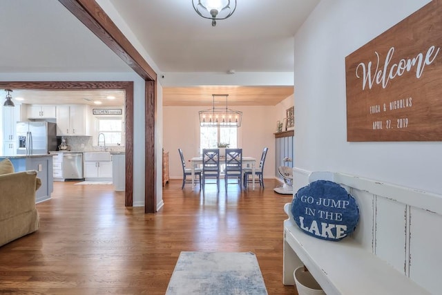 dining space with sink, hardwood / wood-style floors, and a chandelier