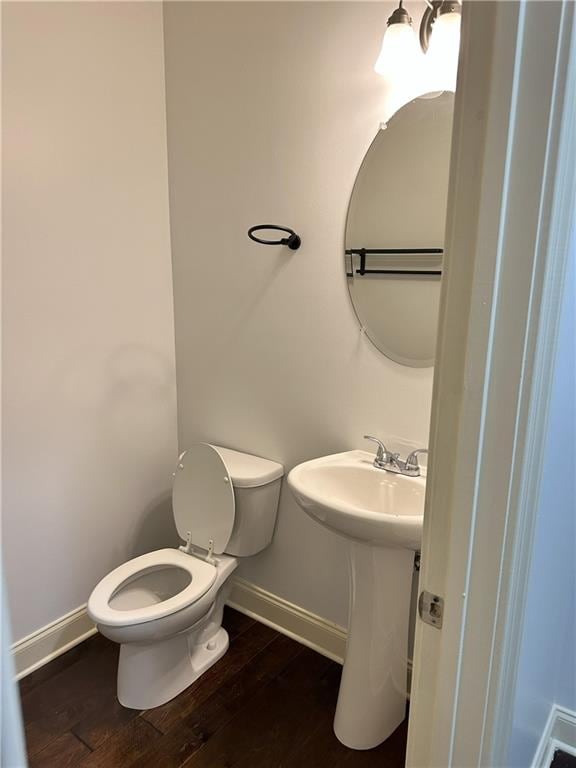 bathroom with toilet, hardwood / wood-style floors, and sink