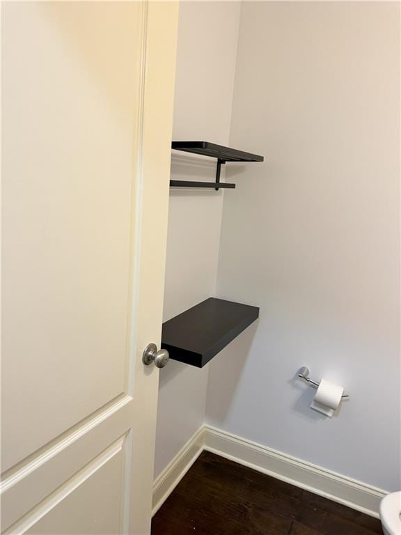 interior details featuring toilet and hardwood / wood-style floors