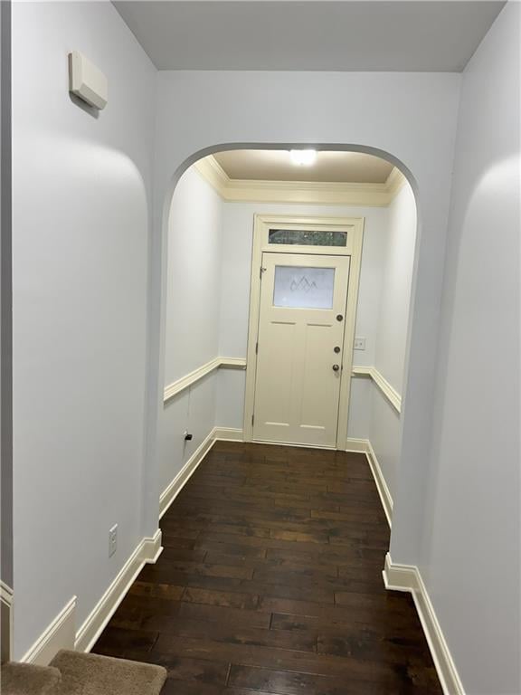 doorway to outside with ornamental molding and dark hardwood / wood-style floors