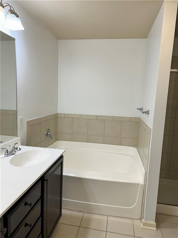 bathroom featuring vanity, tile patterned floors, and a bath