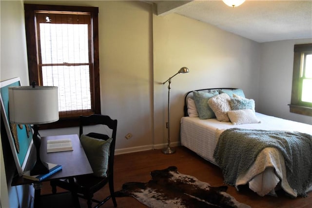 bedroom featuring baseboards, lofted ceiling, and wood finished floors
