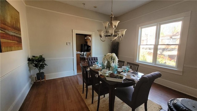 dining area with dark wood-style flooring, baseboards, and a chandelier