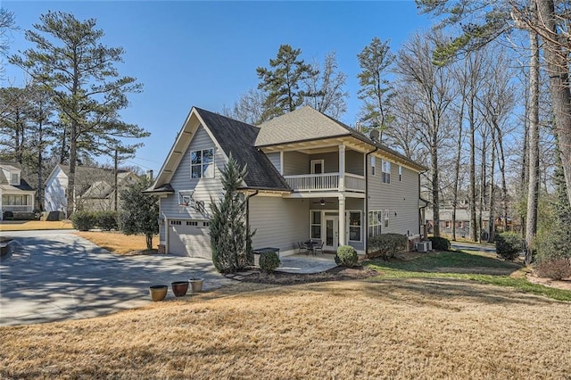2987 Jefferson St, Atlanta, GA 30341 - rear view of property featuring a balcony, a ceiling fan, concrete driveway, an attached garage, and a lawn
