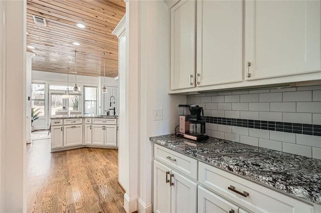 2987 Jefferson St, Atlanta, GA 30341 - kitchen featuring wooden ceiling, light wood-type flooring, dark stone countertops, a sink, and decorative backsplash