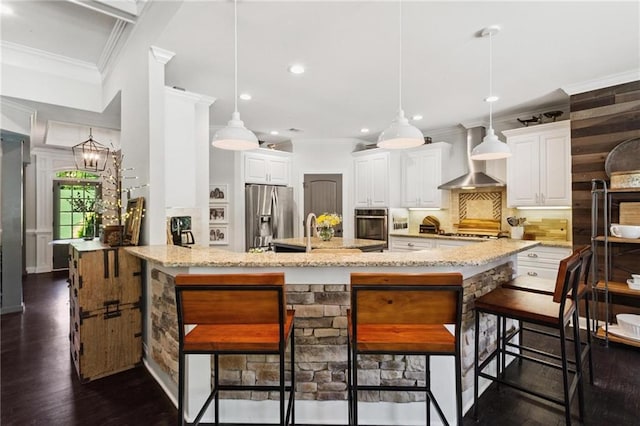 119 Sharp Mountain Crk, Ball Ground, GA 30107 - kitchen with appliances with stainless steel finishes, crown molding, wall chimney exhaust hood, decorative backsplash, and a kitchen breakfast bar