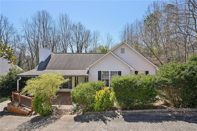 view of front of home with roof with shingles and a chimney