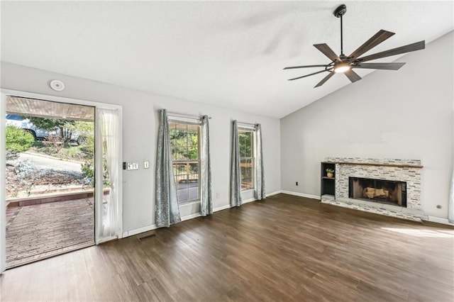 unfurnished living room featuring visible vents, a fireplace with raised hearth, wood finished floors, lofted ceiling, and ceiling fan