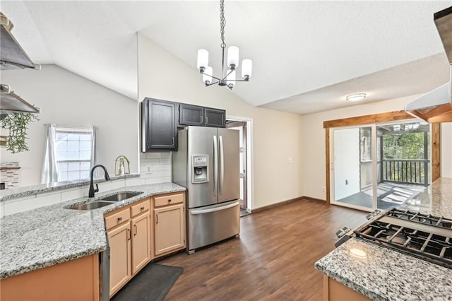 kitchen with vaulted ceiling, a notable chandelier, stainless steel refrigerator with ice dispenser, and a sink