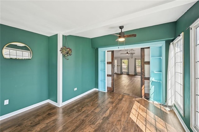 empty room with wood finished floors, baseboards, and ceiling fan