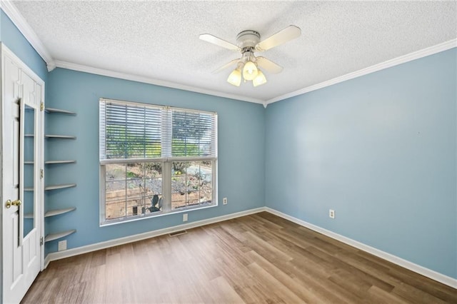 unfurnished room with a ceiling fan, a textured ceiling, wood finished floors, crown molding, and baseboards