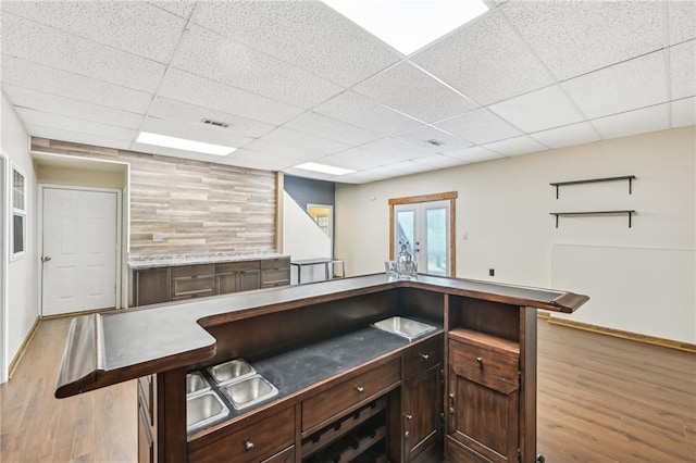 bar featuring a drop ceiling, visible vents, wood finished floors, and french doors