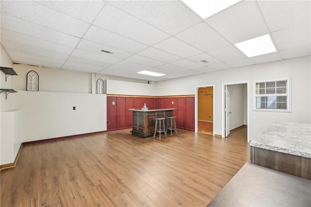 kitchen with a drop ceiling, visible vents, and light wood-style floors